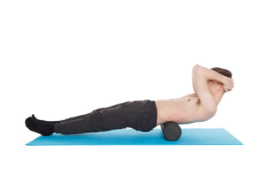 Handsome man shows exercises using a foam roller