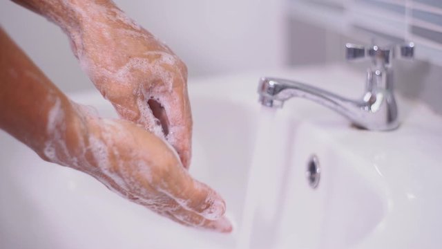 Man washing  hand with soap and water under faucet at sink Inside the house to prevent infection from the coronavirus,covid-19