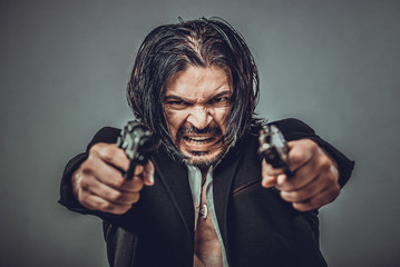 sexy muscular body model portrait of a young man holding a gun in his hands