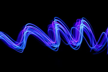 Long exposure photograph of neon blue streaks of light in an abstract swirl, parallel lines pattern against a black background. Light painting photography.