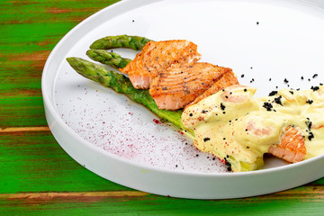 Salmon on asparagus with turmeric and shrimp sauce.