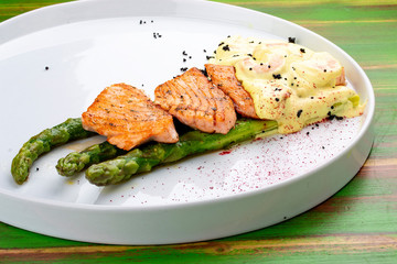 Salmon on asparagus with turmeric and shrimp sauce.