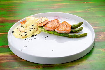 Salmon on asparagus with turmeric and shrimp sauce.