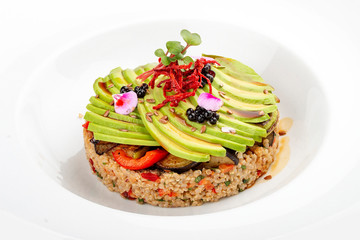 Salad with quinoa, avocado and roasted vegetables.  On a colored wooden background. Vegetarian dish.