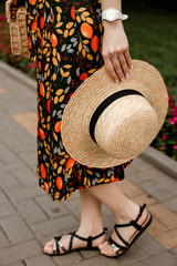 woman with a straw hat. hand holding straw hat. summer fashion accessories hat. summer stylish outfit details