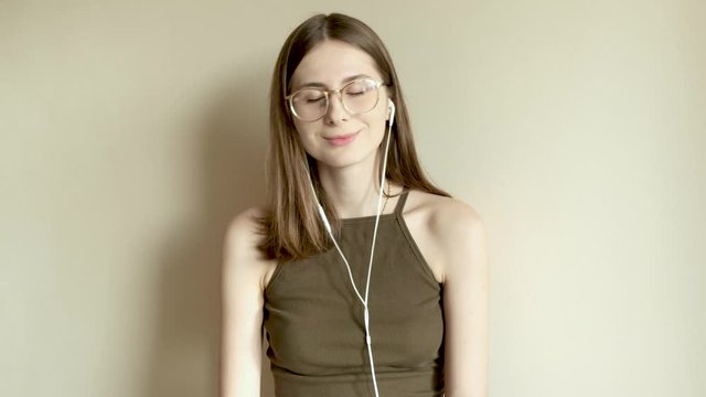 young millennial woman in glasses listening to music while shooting herself on the phone