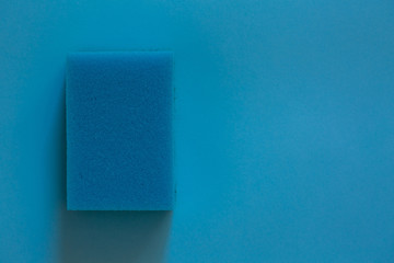 The concept of cleaning and washing. Blue sponge for cleaning on a blue background.
