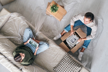 Obraz premium Affectionate couple discussing their plans for the future while unpacking boxes