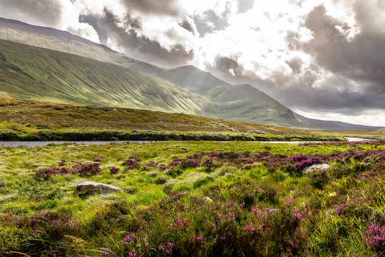 Spectacular bright landscape of the incredible mountains and a river of the Scottish Highlands in the summer.