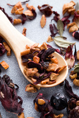 herbal fruit tea with wood spoon on blue background. currant with lingonberry leaf, apple and hibiscus.