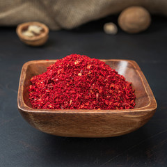 spices seasonings and grains on a square wooden bowl on a dark background and burlap