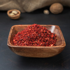 spices seasonings and grains on a square wooden bowl on a dark background and burlap