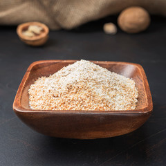 spices seasonings and grains on a square wooden bowl on a dark background and burlap