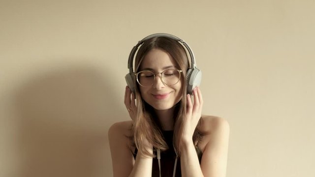 young millennial woman in glasses listening to music while shooting herself on the phone