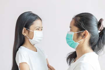The mother and daughter wear a protective medical mask.