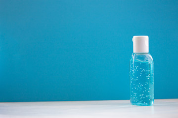 A bottle of hand sanitizer gel. Hand hygiene as coronavirus protection. Antivirus and antibacterial product. Blue liquid with white round granules. Copy space for text