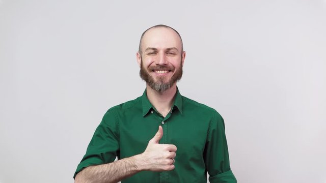 Happy bearded man wearing shirt showing thumbs up sign over white background. Good job, very well.