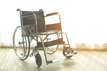 Fototapeta na wymiar Wheelchair with morning sun by the window background in room hospital. Wheelchairs waiting for patient services. with copy space empty on right area.
