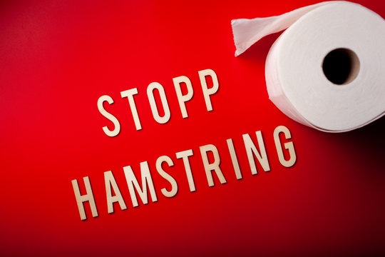 stopp hamstring norwegian word text wooden letter toilet paper on red background coronavirus covid-19