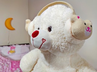 Cute white teddy bear wearing headphones