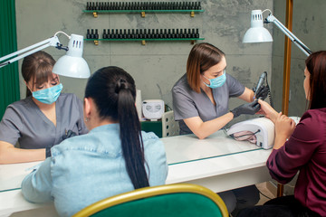 Women getting a manicure in beauty salon.