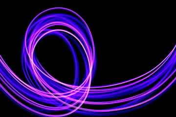 Long exposure photograph of neon purple streaks of light in an abstract swirl, parallel lines pattern against a black background. Light painting photography.
