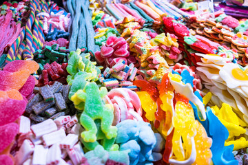 Colorful assorted sweets and candy background: marmalade, toffee, licorice, jolly, jelly baby, jellybean, toffee, pink, yellow, blue. Closeup stock photo