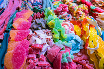 Colorful assorted sweets and candy background: marmalade, toffee, licorice, jolly, jelly baby, jellybean, toffee, pink, yellow, blue. Closeup stock photo