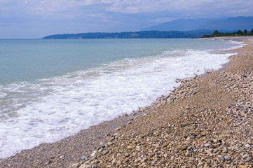 Fototapeta na wymiar Pebble beach on the Black Sea coast with small waves