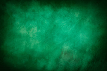 Fototapeta na wymiar An abstract vignette green paint sponged background image.