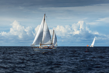 Old expensive vintage wooden sailboat (yawl) close-up, sailing in an open sea. Dramatic cloudscape. Coast of Maine, US © Alex Stemmer