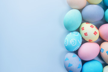 Colorful Easter hunting eggs dyed by colored water with beautiful pattern on pastel blue background, design concept of holiday, top view, copy space.