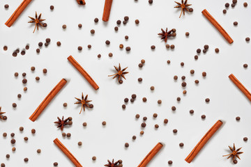 Pattern with cinnamon on a white background, decorated with stars and spices. Tea additive concept...