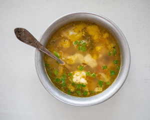 Deep plate with hot homemade soup with cauliflower on chicken broth
