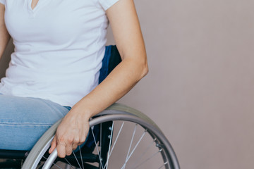 Unrecognizable disabled woman in wheelchair at home. Recovery and healthcare concepts.