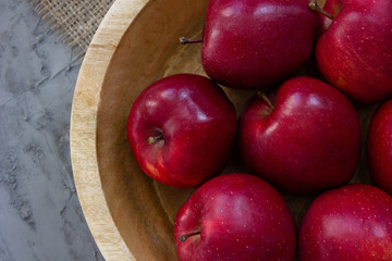 Red apples background. Ripe red apples in wooden box. Top view with space for your text. Apples In Wooden plate On gray concrete table. Organic food and healthy food concept. raw food diet, fruits, 