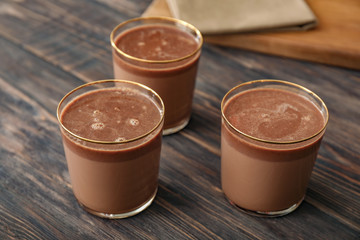 Glasses of hot chocolate on wooden background