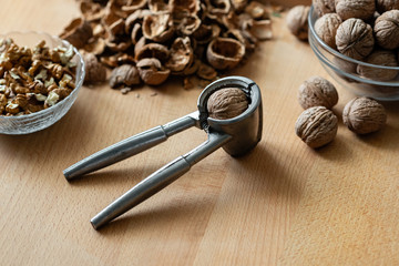 walnuts and nutcracker on wooden background