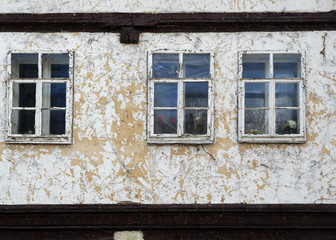 Alte historische sanierungsbedürftige Hausfassade mit drei Fenstern