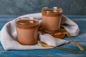 Glasses of hot chocolate on wooden background