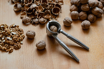 Fototapeta na wymiar walnuts and nutcracker on wooden background
