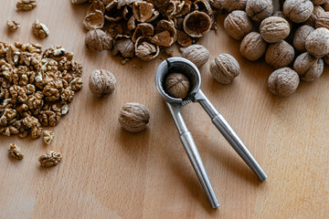 Fototapeta na wymiar walnuts and nutcracker on wooden background
