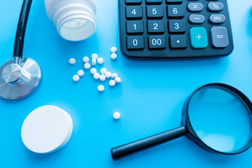 pills and medicines under a magnifying glass next to a medical stethoscope. The concept of health...