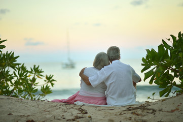 Fototapeta premium Happy elderly couple resting on tropical beach