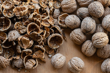 whole and broken walnuts on a wooden background