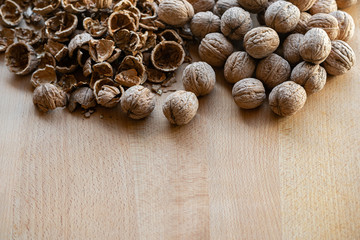 whole and broken walnuts on a wooden background