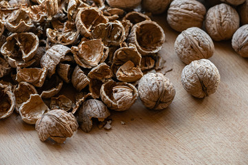 whole and broken walnuts on a wooden background