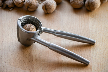 nutcracker and walnuts on wooden background