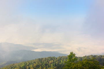 Nature landscape cloudy sky with mountain view and white fog in morning time at Thailand. Nature park and outdoor background