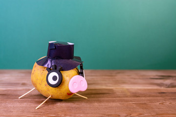 Funny potato in the shape of a pig with a hat on his head